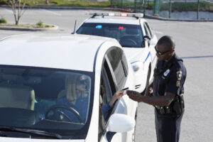 Woman (30s) driving car, pulled over by African American police officer (20s).